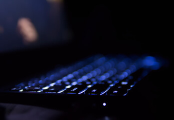 Low Light Macro of Blue Backlit Laptop Keyboard with Soft Bokeh