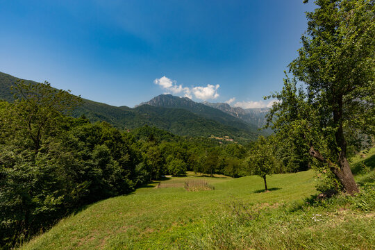 vista panoramica su di un ambiente naturale tra le montagne della regione Lombardia, di giorno, in estate, con cielo sereno