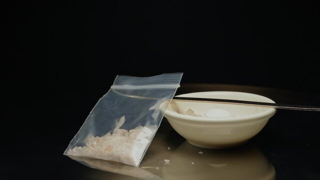 Methamphetamine drug in a plastic bag. Crystal meth or methamphetamine a recreational and highly potent and addictive drug. Crack cocaine in hard form of crystals. Addiction and drug trafficking.