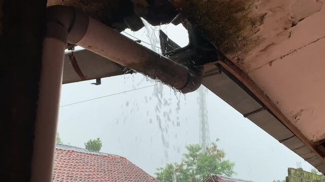 Overflowing Clogged Roof Gutter with Rainwater, Home Maintenance and Water Damage Concept