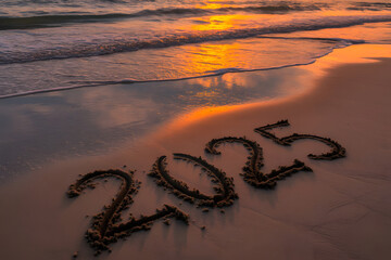 Number 2025 is written in sand of calm beach with orange reflections