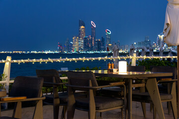 Outdoor dining table overlooking Abu Dhabi Corniche skyline at night