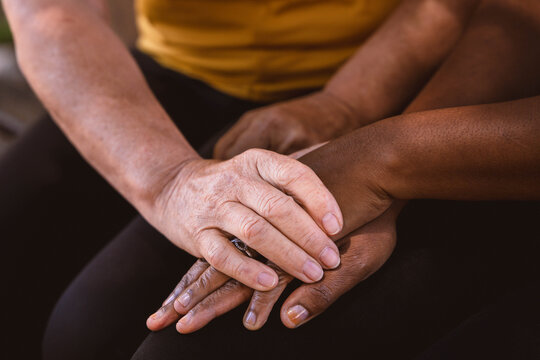 Diverse hands stacking, showing care and support between different generations, symbolizing community, global connection, and lasting friendship. Unidentifiable persons.