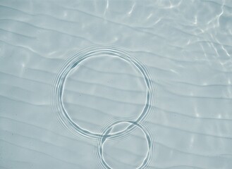Clear water ripple circles on light surface, abstract liquid background symbolizing calmness and purity