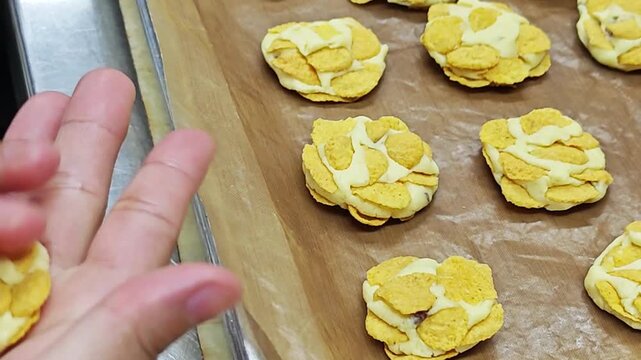 Homemade cornflake cookies carefully shaped by hand, reflecting a warm bakery atmosphere and a delightful sweet dessert.