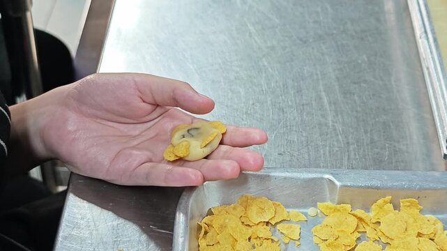 Close-up of shaping cornflake cookies, highlighting homemade bakery style, crispy texture, and a delicious sweet snack.