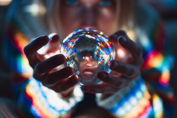 Conceptual image of hands holding a glowing glass sphere with refracted colors and a distorted face, symbolizing future thinking, inner consciousness, intuition, and visionary insight.
