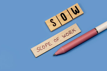 Concept of scope of work or project created on blue background with wooden blocks an copy space.