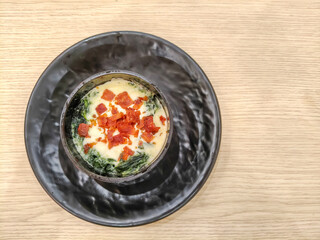 Spinach and cheese lasagna topped with crispy bacon in a cup. Top view