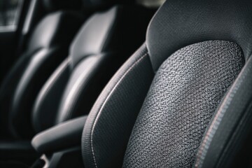 Detailed view of car interior seats with textured fabric inserts and stitching