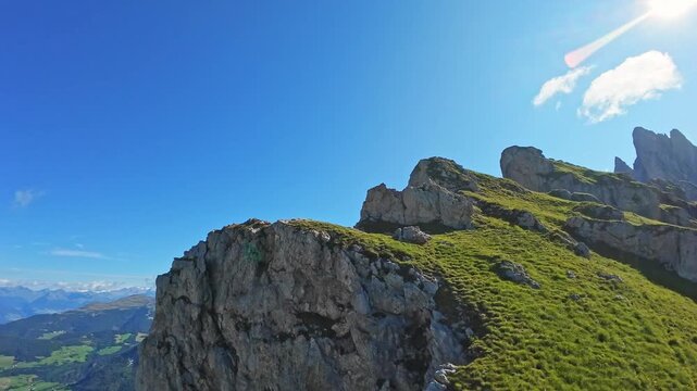 Rock formations and green hills of Seceda mountain in Italys Dolomites during golden hour lighting Rocky cliffs grassy slopes of Seceda mountain in Dolomites, Italy captured in late afternoon light