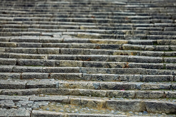 Repeating rows of worn stone steps create strong horizontal rhythm and textured depth, highlighting...