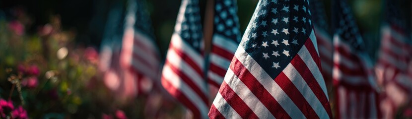 Fototapeta premium Many American flags are displayed in the foreground with soft focus, creating a patriotic scene