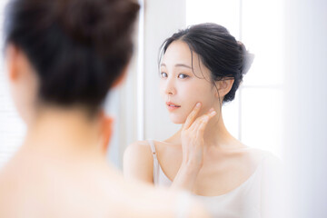 鏡を見るケアする女性　保湿とスキンケア顎周りのケア