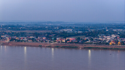 Obraz premium Drone shot of the Savannakhet riverfront at dusk. The image captures the relationship between the urban settlement and the Mekong River border.