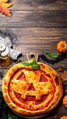 A Halloween pizza shaped like a jack-o'-lantern sits on a rustic wooden table with pumpkins and decorations