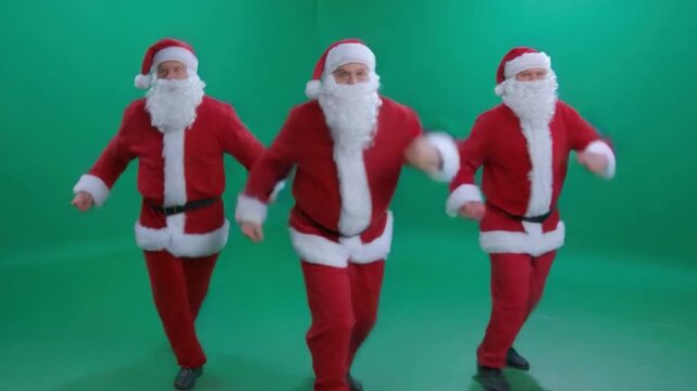 Santa's Merry March: Three figures in the iconic red suits of Santa Claus joyfully dance in unison, their white beards bouncing with holiday cheer.