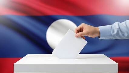 A person's hand casts a vote into a ballot box with the flag of Laos in the background, symbolizing an election or democratic process.