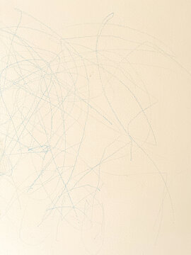 Light beige home wall features messy blue crayon scribbles drawn by a toddler,