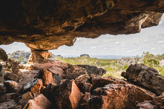 Distinctive limestone bluffs and rugged landscape found in the Chillagoe-Mungana Caves National Park in North Queensland, Australia. A stunning view from beneath a massive limestone rock overhang look