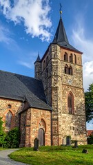 Fototapeta premium Gothic stone church with steeple rising against a partly cloudy sky