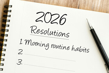 Handwritten 2026 Resolutions list in a spiral notebook with Morning routine habits as the first goal and a pen.