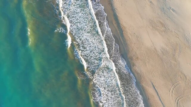 Gelemis, Turkey. Top down view of wave patterns on Patara Beach sand, blue mediterranean sea and foam traces in morning light. Aerial View, HEAD OVER SHOT with rotation, MasterShots