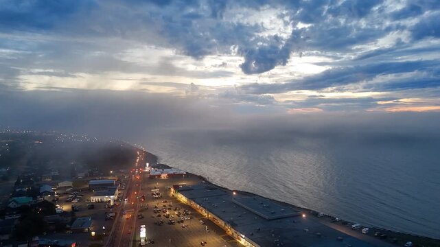 Aerial view of Matane city at dusk with river, fog, low clouds and city lights along St Lawrence River, Quebec, Canada. g.