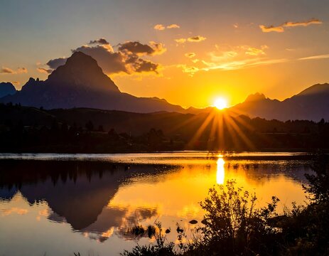 Golden sunset rays burst over mountains, reflected in calm lake - Powered by Adobe