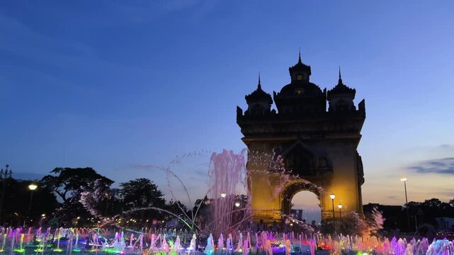 Laos, October 15, 2025: A light and music fountain on the square on the east side of the Patousai Triumphal Arch in Vientiane. A war memorial. Five towers and four passages. Patuxai at night. 4K