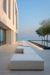Fototapeta premium Modern outdoor seating area by a tranquil poolside, showcasing minimalistic design and stunning views at dusk