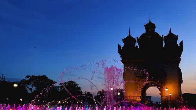 Laos, October 15, 2025: A light and music fountain on the square on the east side of the Patousai Triumphal Arch in Vientiane. A war memorial. Five towers and four passages. Patuxai at night. 4K