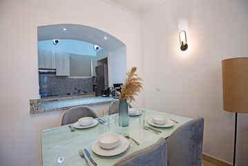 Kitchen area in luxury apartment show home showing open plan interior design decor furnishing with dining table