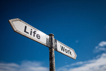 Fototapeta premium Road sign pointing to life and work against a blue sky, symbolizing choices about balance and priorities