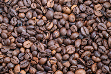 Naklejka premium Background composed of scattered matte finish medium roast coffee beans, Abundant bulk of roasted coffee beans arranged in uniform pattern for packaging backdrop