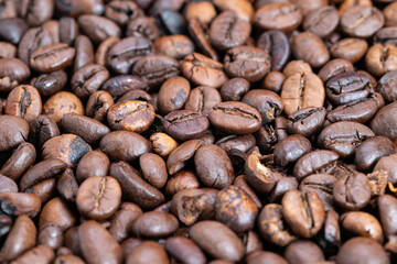 Fototapeta premium Detailed medium roast beans displaying glossy finish and warm hues, Macro image of varying roasted coffee beans showcasing rich brown shades and matte surface texture
