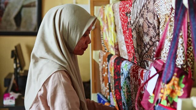Muslim woman shopping for traditional batik fabric