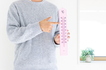 大きな温度計を持つ男性（日本人、顔無し、30代）_冬