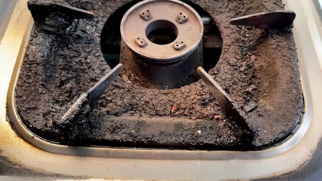 Close up of old rusty and dirty gas stove burner with carbon buildup