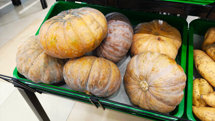 Piles of pumpkins on the shelves of a shop window