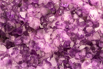 Amethyst purple crystals. Gems. Mineral crystals in the natural environment. Texture of precious and semiprecious stones. Seamless background with copy space colored shiny surface of precious stones.