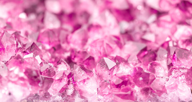 Amethyst pink crystals. Gems. Mineral crystals in the natural environment. Texture of precious and semiprecious stones. Seamless background with copy space colored shiny surface of precious stones.