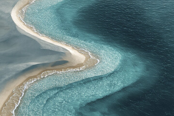 Abstract aerial ocean background with sandbank and gradient water colors, showing natural coastal patterns and waves gently touching shore in serene and calming scene
