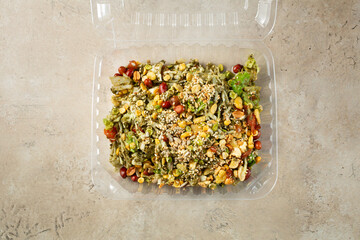 A top down view of tea leaf salad, in a plastic container.