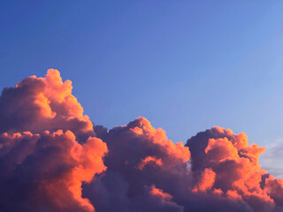 Pink orange clouds at sunset in the evening sky.