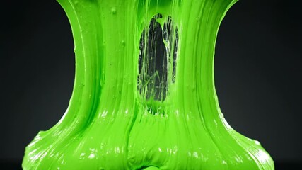 Green Slime Texture: A vibrant, close-up shot of neon green slime, revealing its elastic, gooey consistency with dynamic textures and captivating shapes, perfect for sensory play.