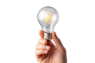 Holding a light bulb in hand with a bright glow while standing against a plain background