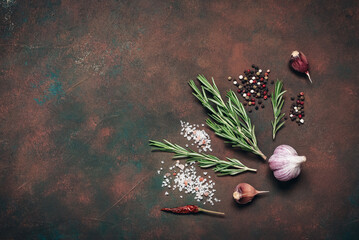 Cooking ingredients, spices, and herbs. Dark brown culinary background. Top view, flat lay, copy space.