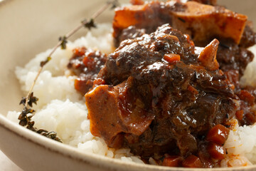A closeup view of a plate of braised oxtail and rice.