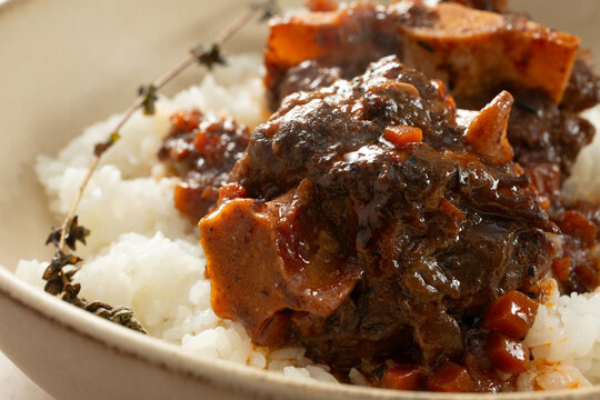 A closeup view of a plate of braised oxtail and rice.